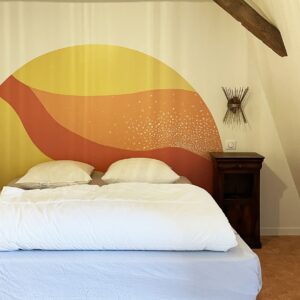 Chambre avec un lit et un motif sur le mur